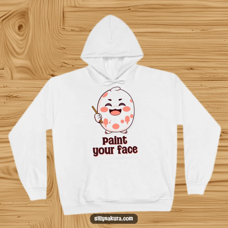 Funny Daruma Hoodie with a character doll enthusiastically painting a big smile, promoting cheerful warmth.